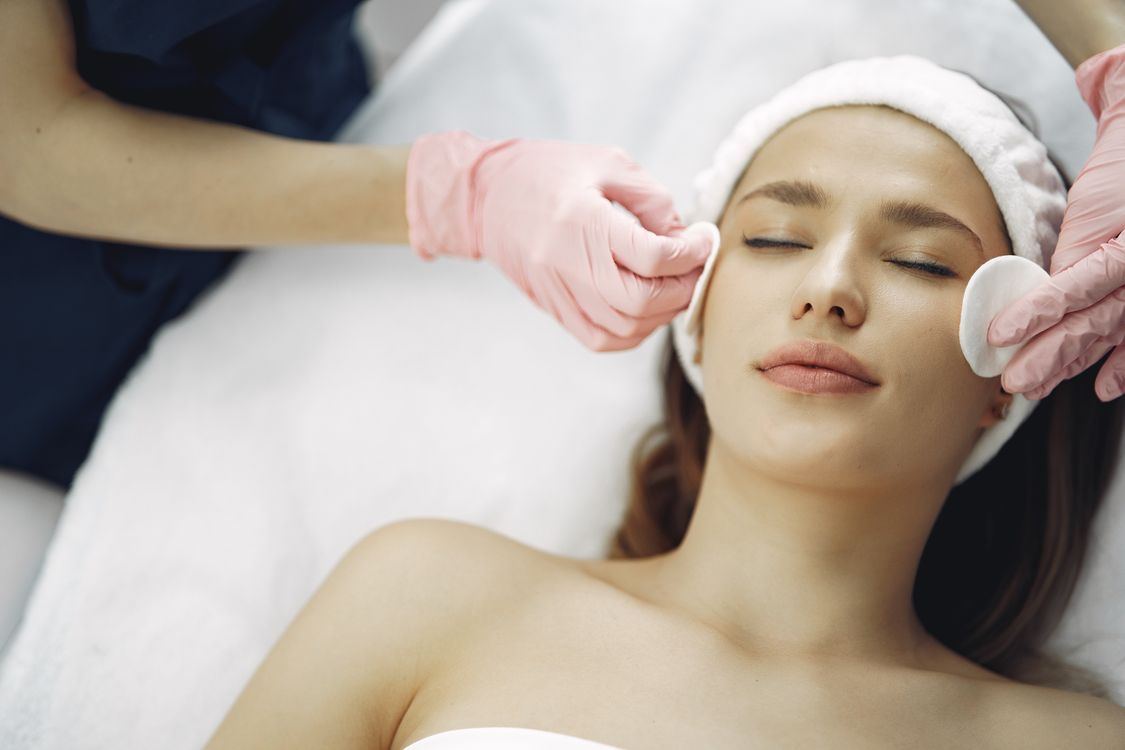 Mulher recebendo tratamento facial em ambiente de clínica de estética